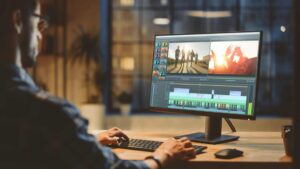 Homme qui fait du montage vidéo sur un logiciel sur son ordinateur