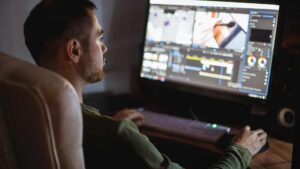 Homme qui fait du montage vidéo sur son logiciel