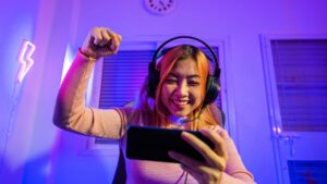 Femme qui joue à des jeux vidéos sur son smartphone