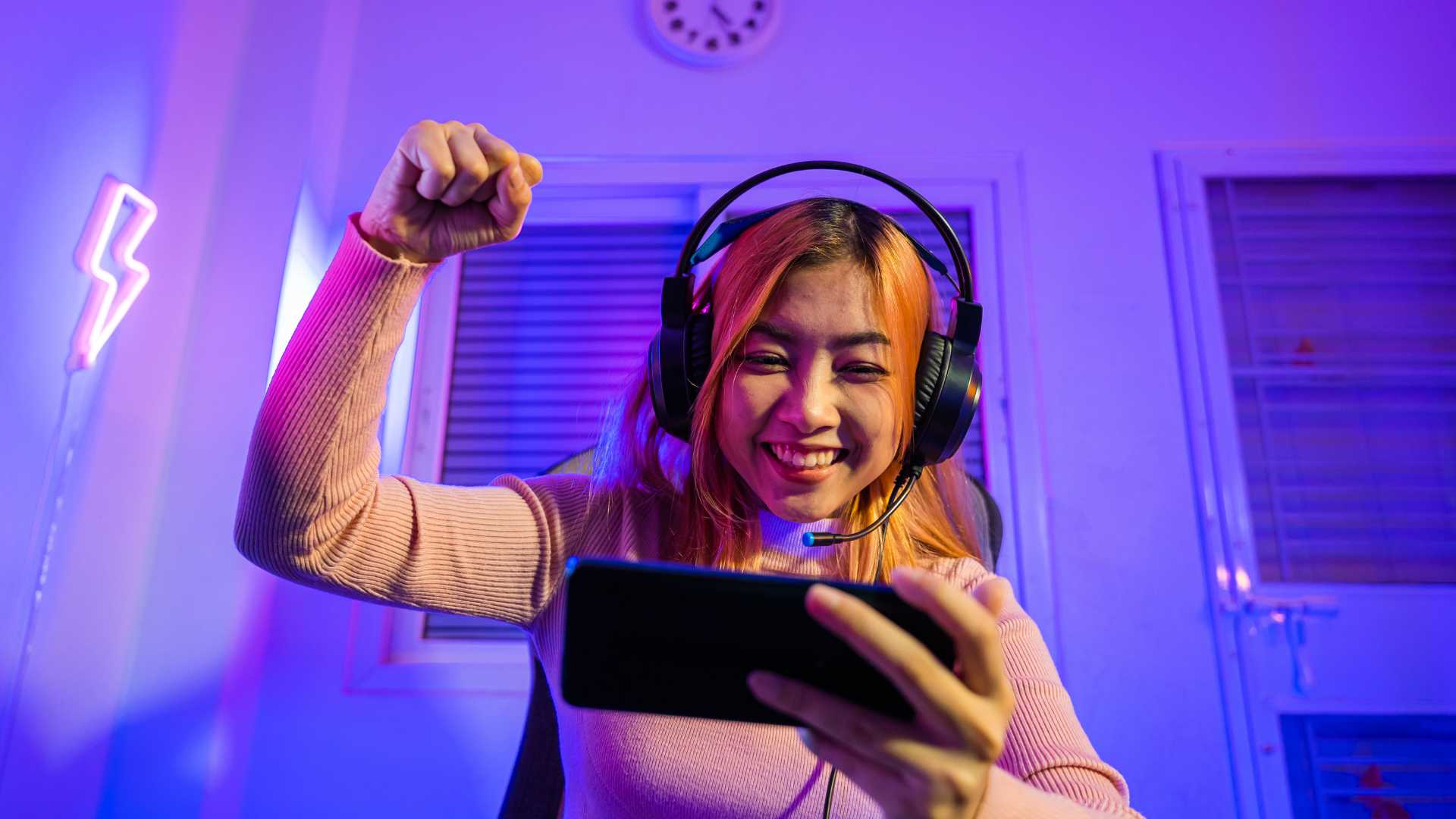 Femme qui joue à des jeux vidéos sur son smartphone